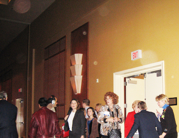 People standing beside an exit door, with circular light spots (angel orbs) overhead
