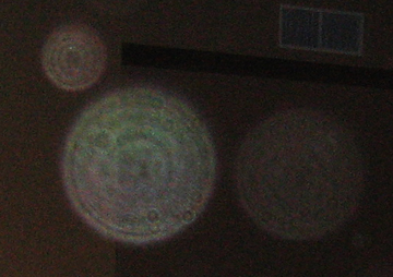 Close-up of several colored circular light spots (angel orbs) in a photograph