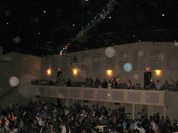 Auditorium ceiling with numerous pale circular light spots (angel orbs) in the photograph