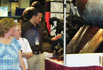 Children and an adult beside a globe sculpture, with circular light spots (angel orbs) in the photograph