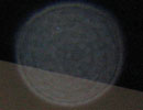 Translucent circular orb with faint rings overlapping a diagonal gray edge against a dark background