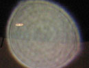 Pale yellow circular light spot (angel orbs) with a faint patterned center