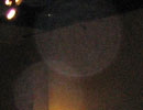 Faint translucent circular orb against a dark ceiling