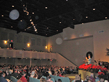 Auditorium audience with multiple round light spots above the seating