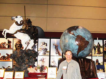 Man beside an exhibition of sculptures, including a globe and mounted rider