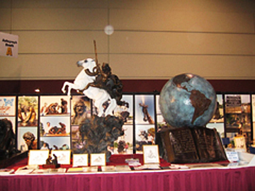 Exhibit table displaying sculptures, photographs and a globe