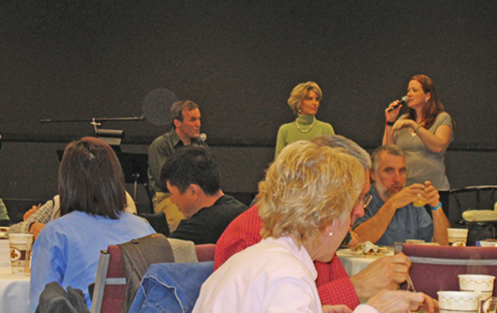People speaking beside a table in a meeting room