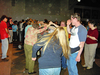 People gathered with a colorful flag, with circular light spots (angel orbs) in the photograph
