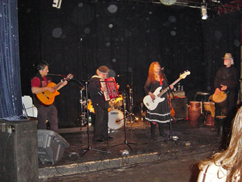 Band performing onstage with circular light spots (angel orbs) above