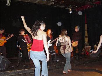 People standing before a band with raised arms and circular light spots (angel orbs) overhead