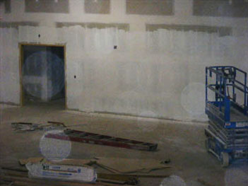 Unfinished room with exposed walls, construction materials and pale circular light spots (angel orbs)