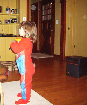 Child standing in a living room holding a small object