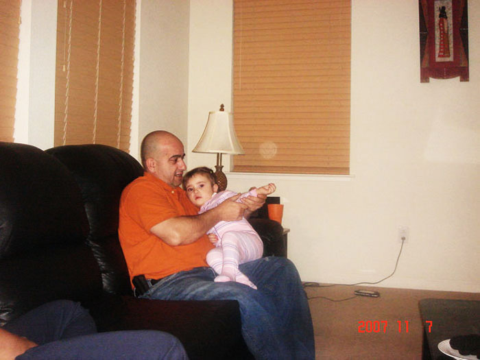 Man on a sofa holding a small child
