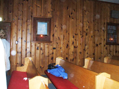 Wood-paneled church interior with an American flag and circular light spots (angel orbs)