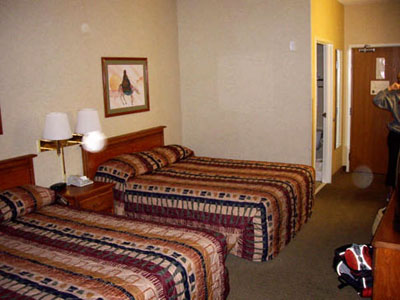 Bedroom with two beds and a pale circular spot (angel orbs) near a lamp