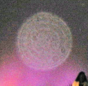 Large pale circular light spot (angel orbs) with a pink-purple glow beneath it