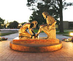 Bronze lion sculpture on a circular fountain before a stone building