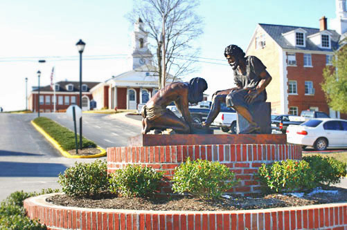 Divine Servant® on a circular brick display in a landscaped campus setting