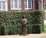 Fisher of Men® standing against an ivy-covered brick wall