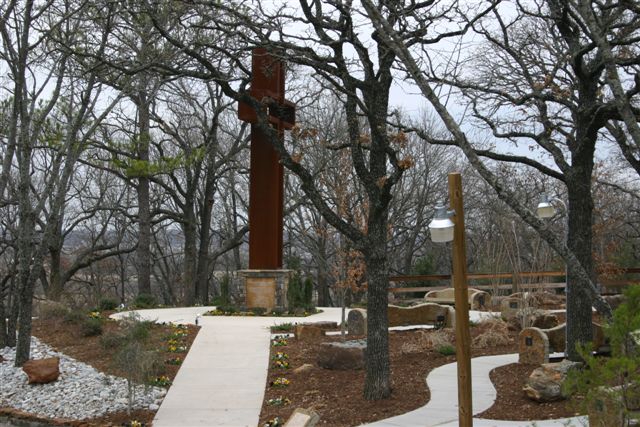The Empty Cross™ viewed beyond a wooden fence and bare trees