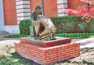 Rear view of Divine Servant® on a brick pedestal in a church courtyard
