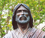 Close-up of a bronze figure's face framed by draped fabric