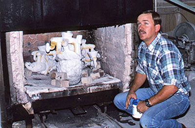 Max Greiner beside a kiln loaded with sculpture molds