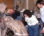 Visitors examining bronze Divine Servant® components in a workshop
