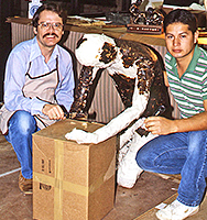 Two men beside a figure armature in progress