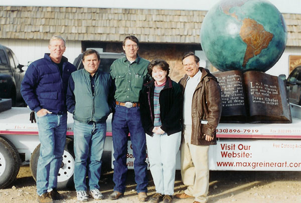 Foundry group posing beside The Great Commission® globe sculpture