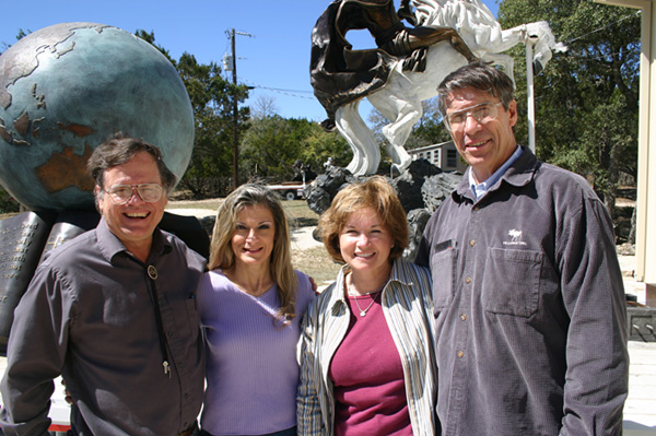 Four visitors posing together before outdoor sculptures