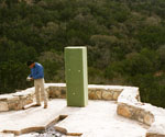 Worker beside a tall block of green modeling foam outdoors