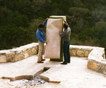 Workers positioning a full-length figure template against green foam