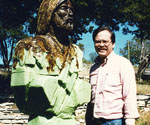 Artist beside the partly covered green foam figure