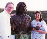 Two visitors posing beside the Fisher of Men® model