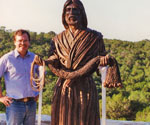 Artist beside the completed Fisher of Men® sculpture outdoors