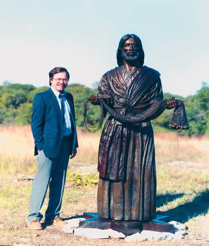 Max Greiner beside a life-size Fisher of Men® sculpture outdoors
