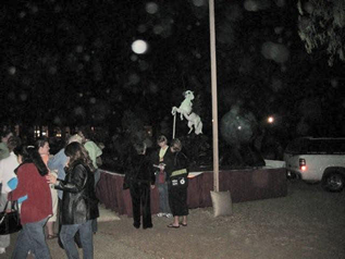 Outdoor nighttime gathering with circular light spots (angel orbs) in the photograph