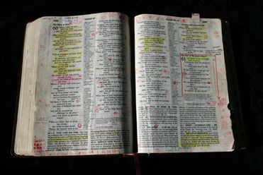 Open Bible with highlighted passages and handwritten notes