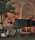 Musician playing a grand piano on a church stage