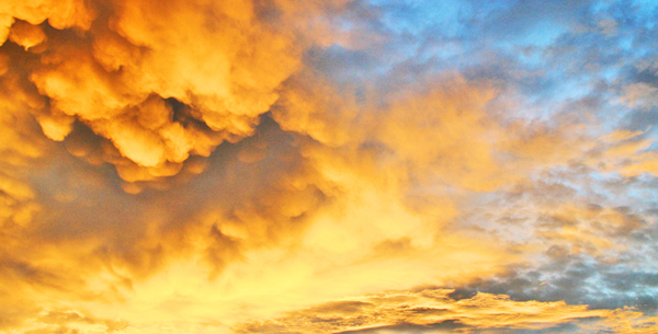 Golden sunset clouds spreading across a blue sky