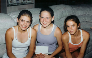 Three young women seated together on a couch