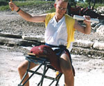 Front view of a costumed model on a saddle holding both arms out