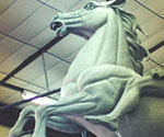 Close view of the rider's draped cloak and extended arm on the clay model