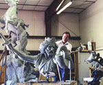 Side view of the artist beside the rider's flowing cloak and the rearing horse