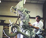 Artist working near the rider's head and the horse's raised front legs