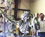 Artist standing behind the rearing horse and rider model