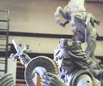 Close view of the rider's extended sword arm, crown and flowing hair