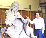 Artist standing beside the detached upper-body model of the crowned rider