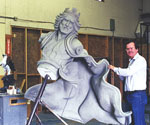 Artist beside the rider's upper-body model, showing the extended arm and cloak